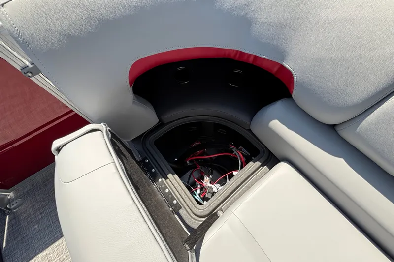 Slide: The Image of 2026 Sun Tracker Party Barge 22 XP3 seat storage compartment with wiring visible. - 16