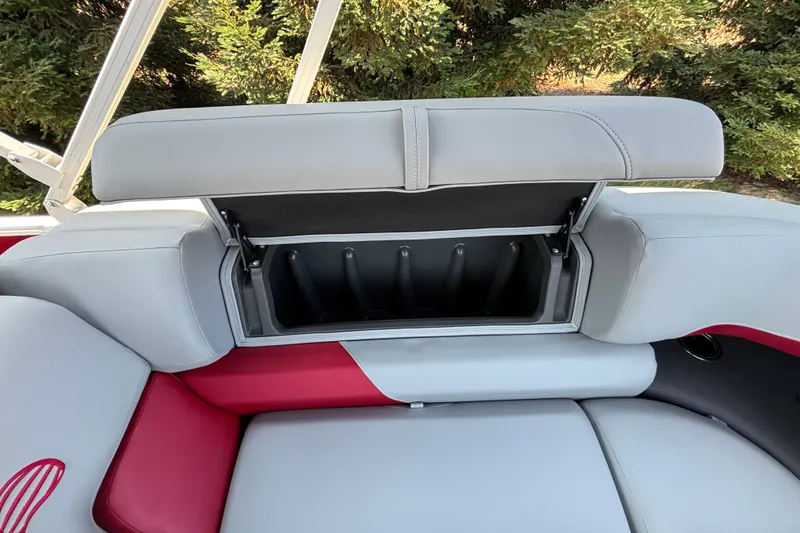 Slide: The Image of 2026 Sun Tracker Party Barge 22 XP3 seat storage compartment, open, with gray and red upholstery. - 19