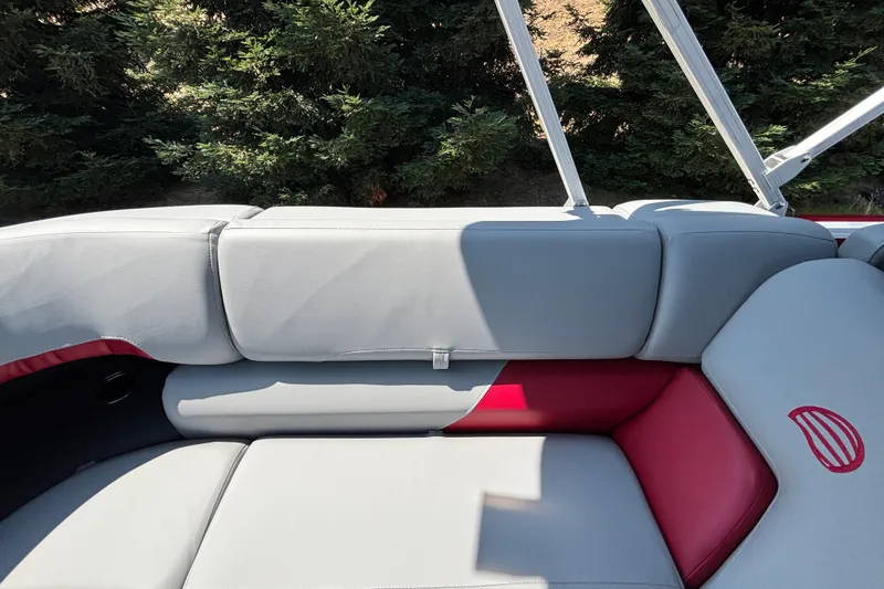 Slide: The Image of 2026 Sun Tracker Party Barge 22 XP3 interior with gray and red seating, surrounded by greenery. - 29