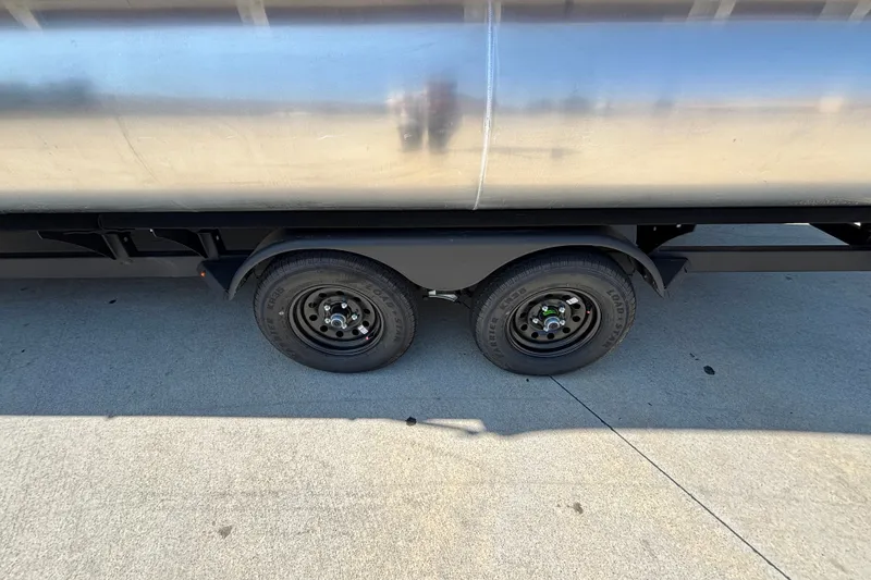 Slide: The Image of 2026 Sun Tracker Party Barge 22 XP3 trailer wheels on concrete surface. - 54