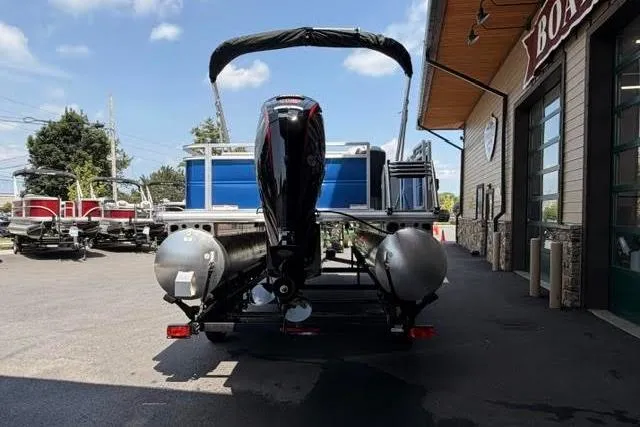 Slide: The Image of 2026 Sun Tracker Party Barge 22 RF DLX pontoon boat parked outside dealership. - 3
