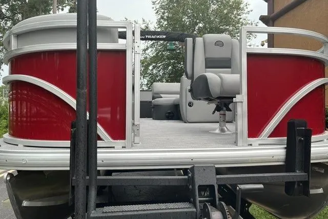 Slide: The Image of 2026 Sun Tracker SportFish 20 DLX pontoon boat with red exterior and gray seating. - 2
