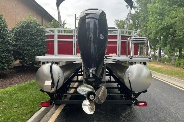 Slide: The Image of 2026 Sun Tracker SportFish 20 DLX pontoon boat, rear view with motor and dual pontoons. - 3