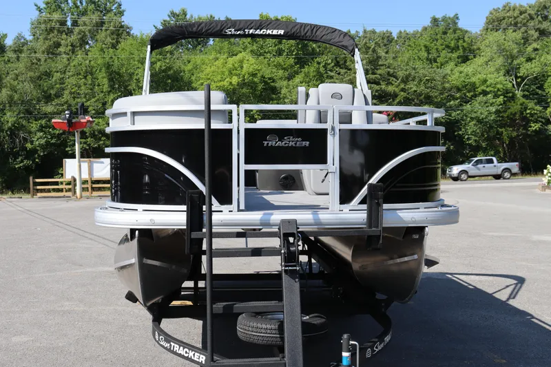 Slide: The Image of 2026 Sun Tracker SportFish 20 DLX pontoon boat on trailer, parked outdoors. - 14