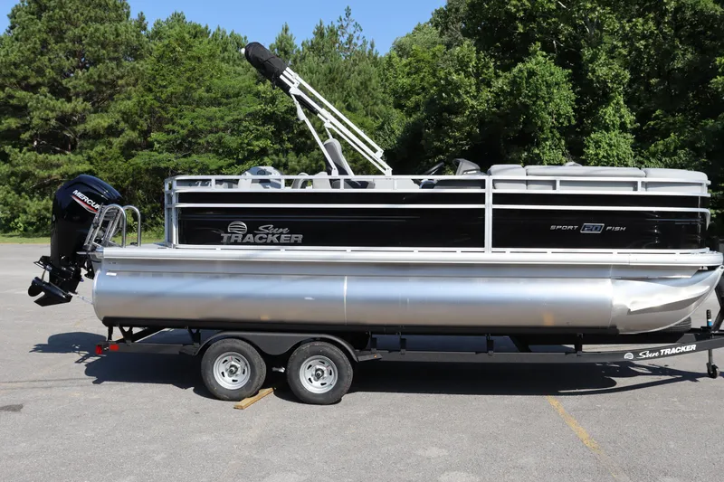 Slide: The Image of 2026 Sun Tracker SportFish 20 DLX pontoon boat on trailer, parked outdoors. - 16