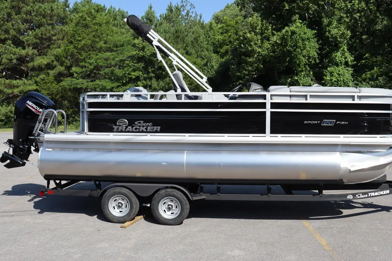 Slide: The Image of 2026 Sun Tracker SportFish 20 DLX pontoon boat on trailer, parked outdoors. - 17