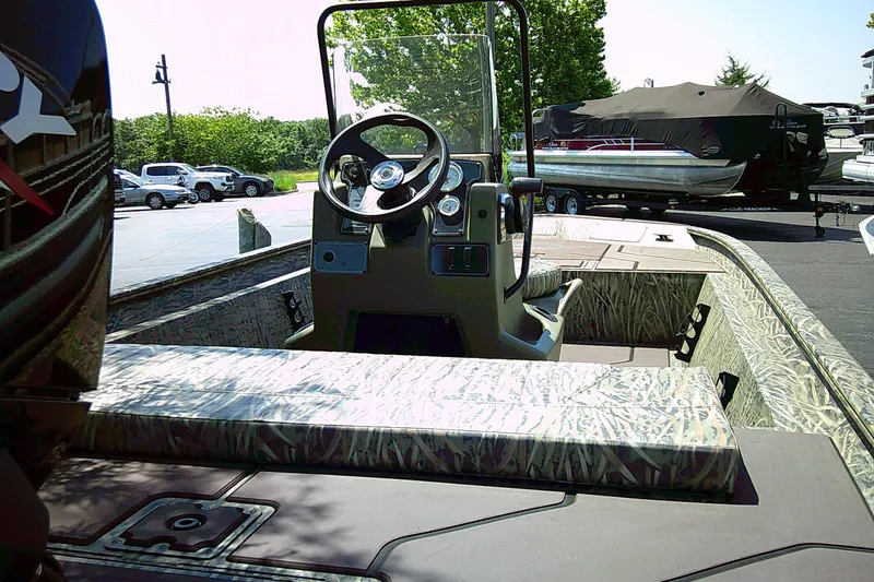 Slide: The Image of 2026 Tracker Grizzly 1860 CC boat with camouflage interior, parked outdoors. - 3