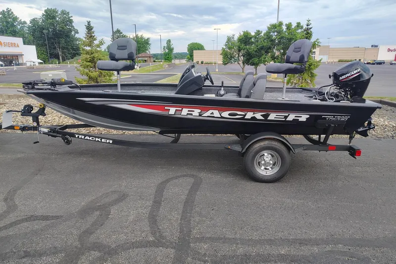The Image of 2026 Tracker Pro Team 175 boat on trailer in parking lot, featuring sleek black design. - 0