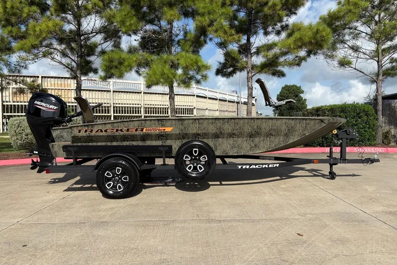 Slide: The Image of 2026 Tracker Grizzly 1756 T Marsh boat on trailer, outdoors with trees in background. - 3