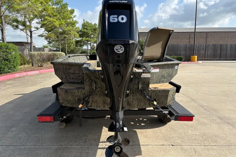 Slide: The Image of 2026 Tracker Grizzly 1756 T Marsh boat with Mercury 60 engine, parked outdoors. - 5