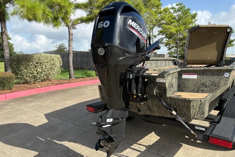 Slide: The Image of 2026 Tracker Grizzly 1756 T Marsh boat with Mercury 60 outboard motor in a parking lot. - 6