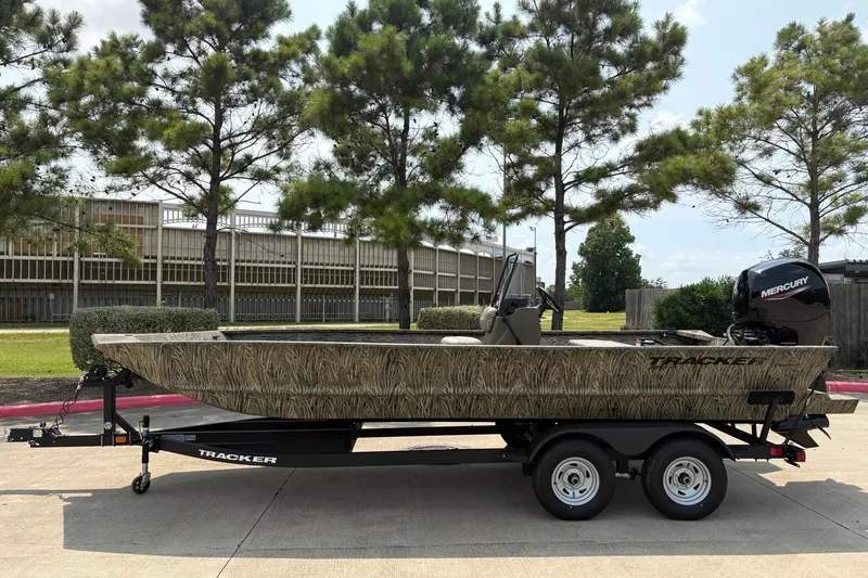 The Image of 2026 Tracker Grizzly 2072 CC boat on trailer, parked outdoors near trees. - 0