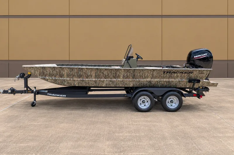 The Image of 2026 Tracker Grizzly 2072 CC boat on trailer, camo design, parked outdoors. - 0