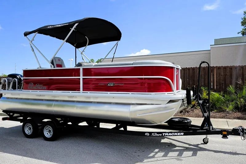 Slide: The Image of 2026 Sun Tracker Party Barge 20 DLX pontoon boat on trailer, red and silver design. - 4