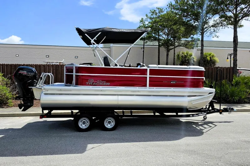 The Image of 2026 Sun Tracker Party Barge 20 DLX pontoon boat on trailer, parked outdoors. - 0