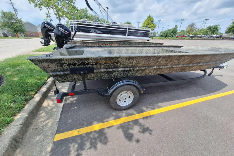 Slide: The Image of 2026 Tracker Grizzly 1860 Utility boat on trailer in parking lot. - 18