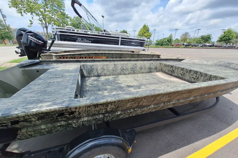Slide: The Image of 2026 Tracker Grizzly 1860 Utility boat with camouflage design in a parking lot. - 17