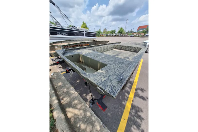 Slide: The Image of 2026 Tracker Grizzly 1860 Utility boat in parking lot, camo design, sunny day. - 20