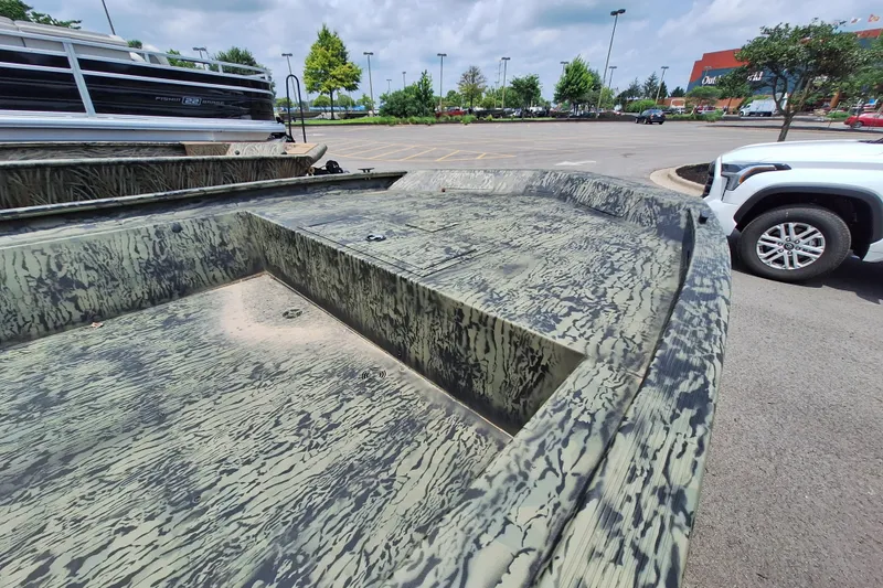 Slide: The Image of 2026 Tracker Grizzly 1860 Utility boat with camouflage design in a parking lot. - 15