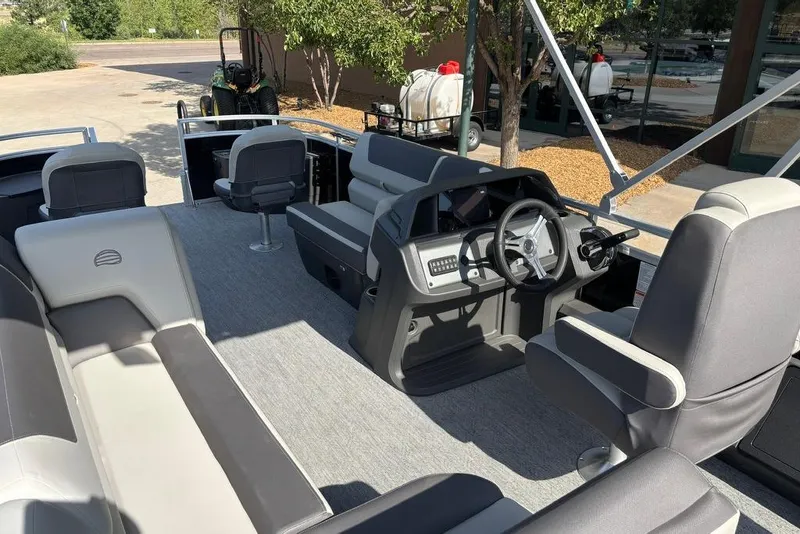 Slide: The Image of 2026 Sun Tracker Fishin' Barge 22 DLX interior with seating and steering console. - 6
