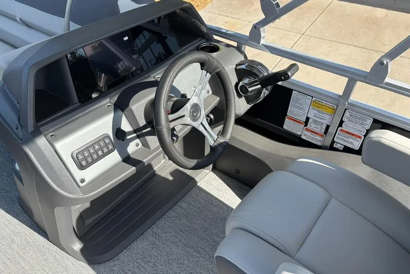 Slide: The Image of 2026 Sun Tracker Fishin' Barge 22 DLX steering console with modern controls and comfortable seating. - 7