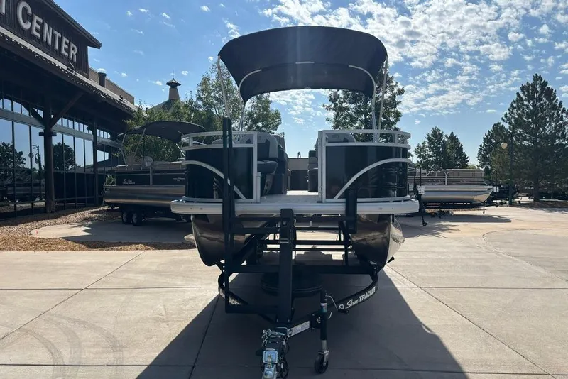 Slide: The Image of 2026 Sun Tracker Fishin' Barge 22 DLX pontoon boat displayed outdoors under a sunny sky. - 2