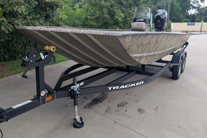 The Image of 2026 Tracker Grizzly 2072 CC boat on trailer, camo design, parked outdoors. - 0