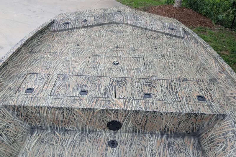 Slide: The Image of 2026 Tracker Grizzly 2072 CC boat with camouflage deck pattern, parked outdoors. - 10