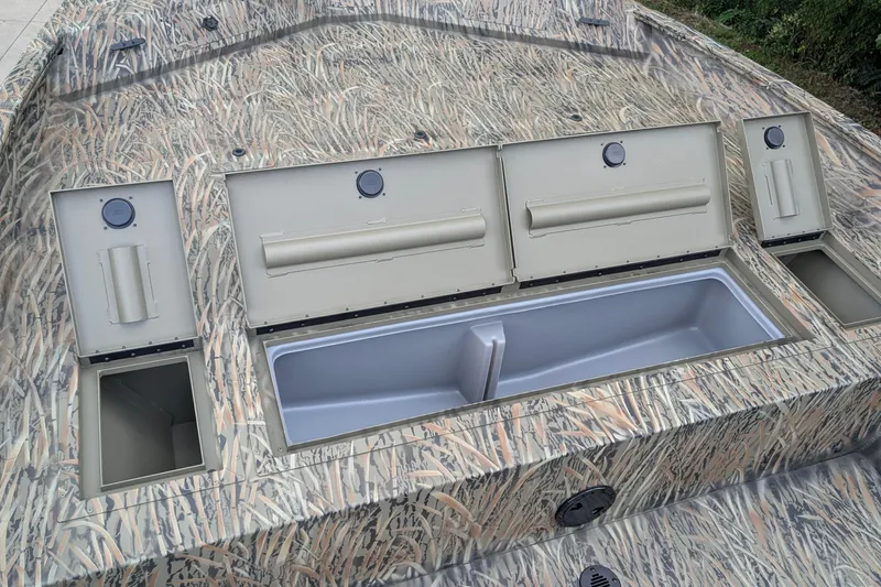 Slide: The Image of 2026 Tracker Grizzly 2072 CC boat with open storage compartments and camouflage design. - 11