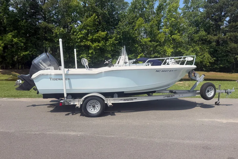 The Image of 2015 Tidewater 180 CC Adventure boat on trailer, parked on road with trees in background. - 0