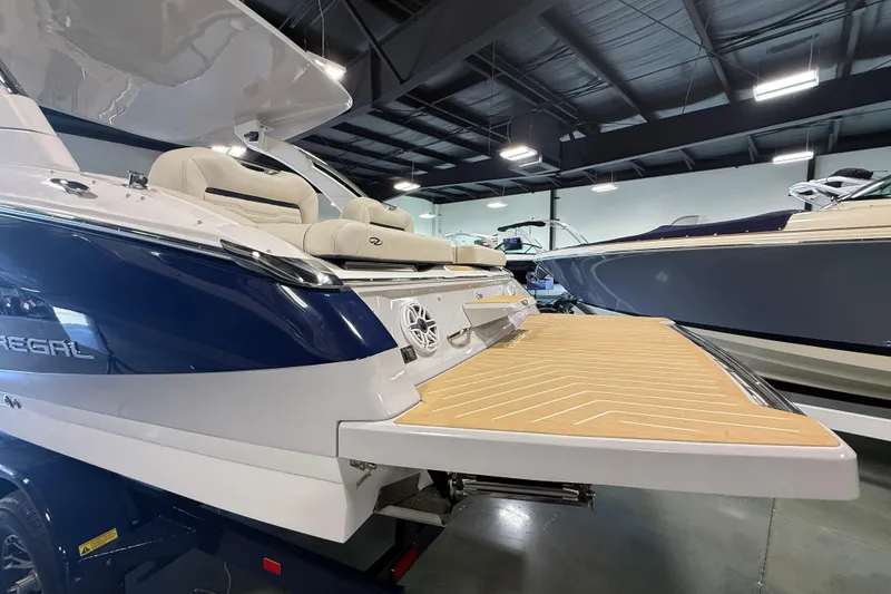Slide: The Image of 2027 Regal LS9 boat with spacious deck, showcased in a modern indoor marina. - 3
