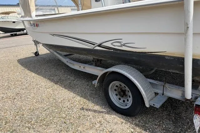 Slide: The Image of 2017 Carolina Skiff 21 DLX boat on trailer, parked on gravel surface. - 13