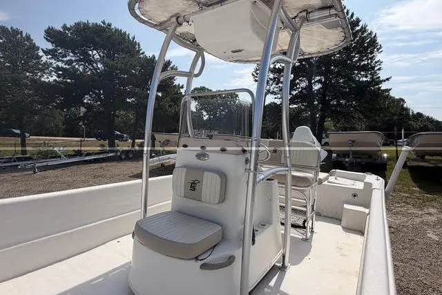 Slide: The Image of 2017 Carolina Skiff 21 DLX boat with center console and T-top, parked outdoors. - 3