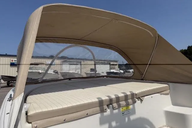Slide: The Image of 2017 Carolina Skiff 21 DLX boat with beige canopy and cushioned seating. - 12