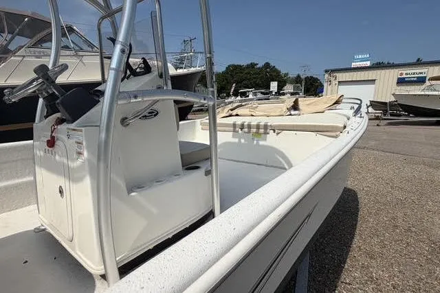 Slide: The Image of 2017 Carolina Skiff 21 DLX boat in a marina, showcasing console and seating. - 11
