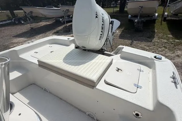 Slide: The Image of 2017 Carolina Skiff 21 DLX boat with Suzuki outboard motor, rear seating, and storage compartments. - 8