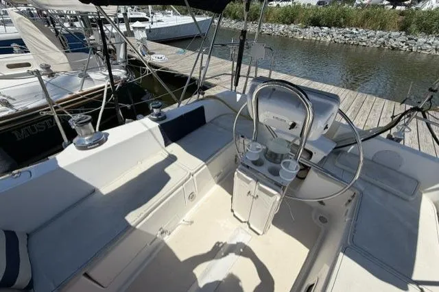 Slide: The Image of Cockpit of 2002 Saga 43 sailboat with steering wheel and seating, docked at marina. - 7