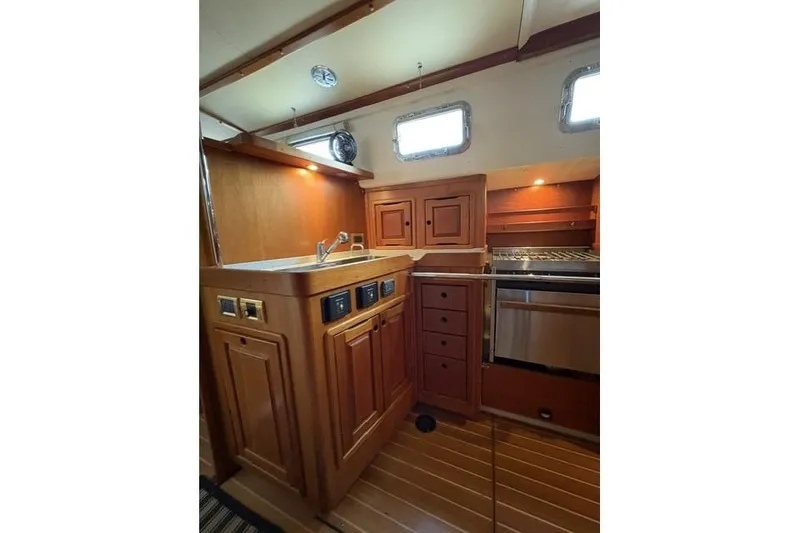 Slide: The Image of Wooden yacht kitchen interior with sink, stove, and cabinets in a 2002 Saga 43 model. - 16
