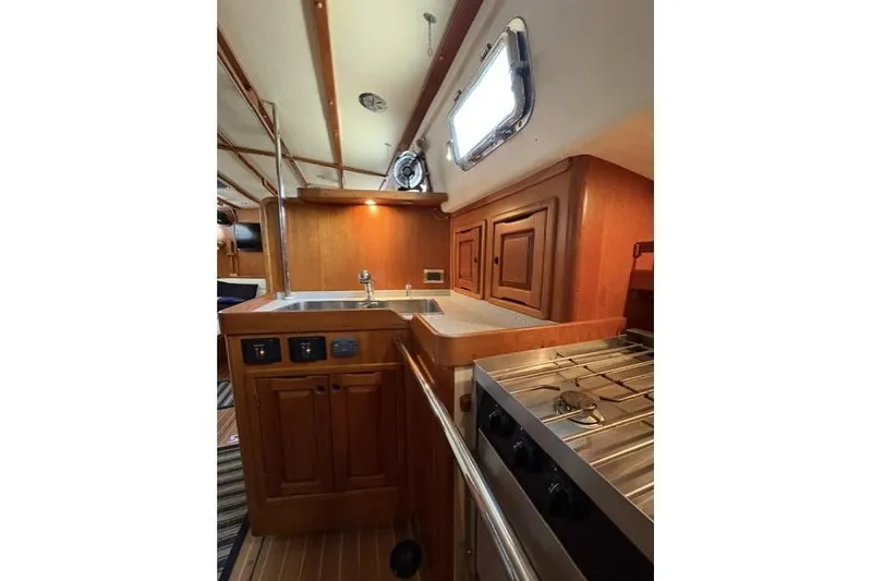 Slide: The Image of Interior of 2002 Saga 43 yacht featuring a wooden galley with stove and sink. - 18