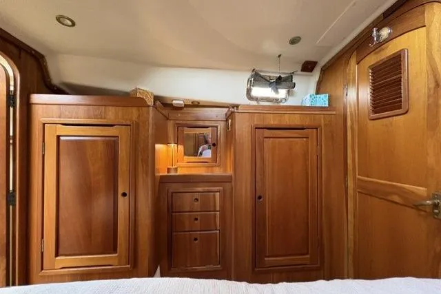 Slide: The Image of Wooden interior of a 2002 Saga 43 boat, featuring cabinets and drawers. - 28