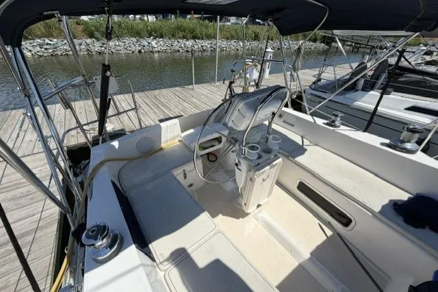 Slide: The Image of Cockpit of 2002 Saga 43 sailboat docked at marina, featuring steering wheel and seating area. - 6