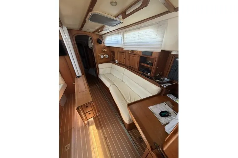 Slide: The Image of Interior of 2002 Saga 43 sailboat with wooden furnishings and white seating. - 24