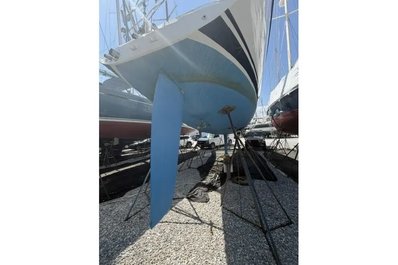 Slide: The Image of 2002 Saga 43 sailboat on stands, showcasing blue hull and keel in a boatyard. - 44