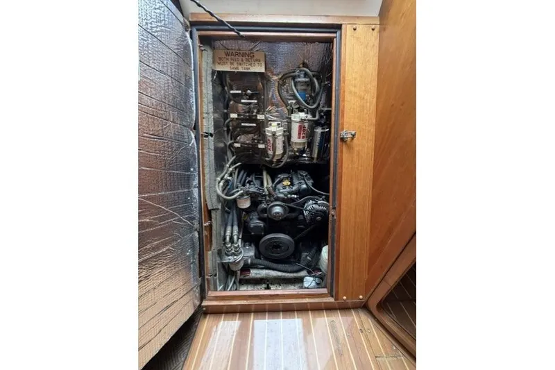 Slide: The Image of Engine compartment of a 2002 Saga 43 sailboat, showcasing mechanical components and wiring. - 37