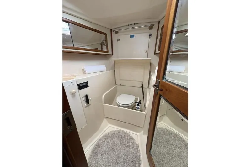 Slide: The Image of Compact bathroom in 2002 Saga 43 yacht with toilet, mirror, and wooden door. - 36