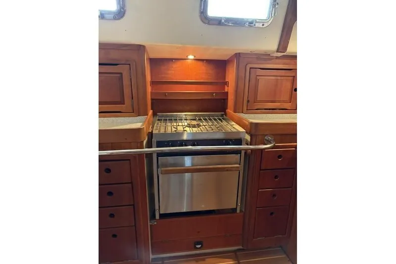 Slide: The Image of 2002 Saga 43 yacht kitchen with wooden cabinetry and stainless steel stove. - 19