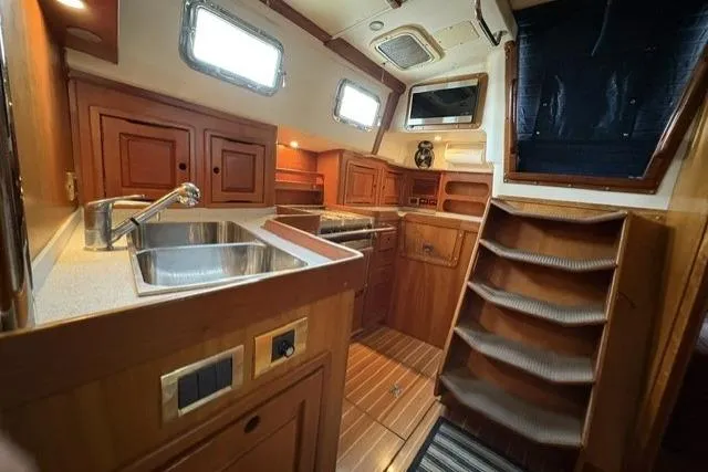 Slide: The Image of Interior of 2002 Saga 43 yacht with wooden cabinetry and stainless steel sink. - 14