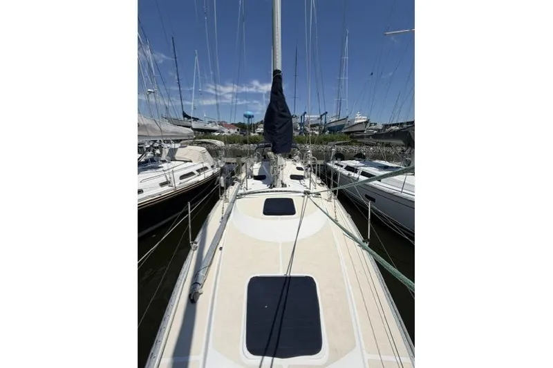 Slide: The Image of 2002 Saga 43 sailboat docked, view of deck and mast under clear blue sky. - 11