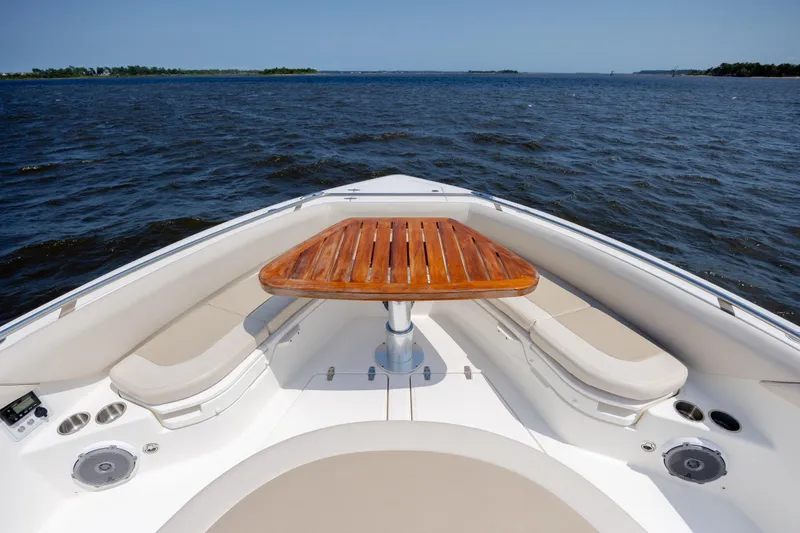 Slide: The Image of 2017 Boston Whaler 420 Outrage boat interior with wooden table and cushioned seating. - 62