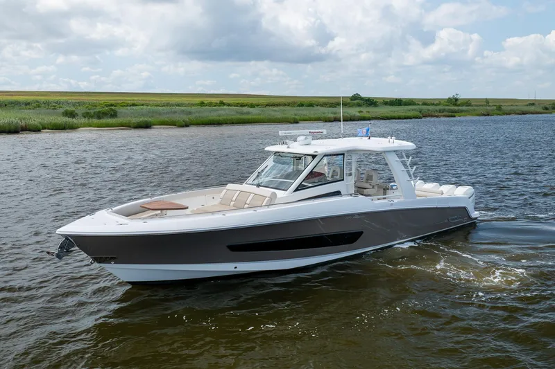 Slide: The Image of 2017 Boston Whaler 420 Outrage cruising on a scenic waterway under a cloudy sky. - 1